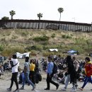 이민자들은 COVID 금지가 종료되도록 설정된 미국-멕시코 장벽 근처에 모입니다. 이미지