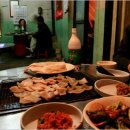 펌)돼지껍데기에 술 한잔, 주모가 펄펄 끓는 물에 삶은 돼지껍데기를 내온다. 은근한 연탄불에 껍데기 겉 부분이 아래로 향하게 해서 굽는 이미지